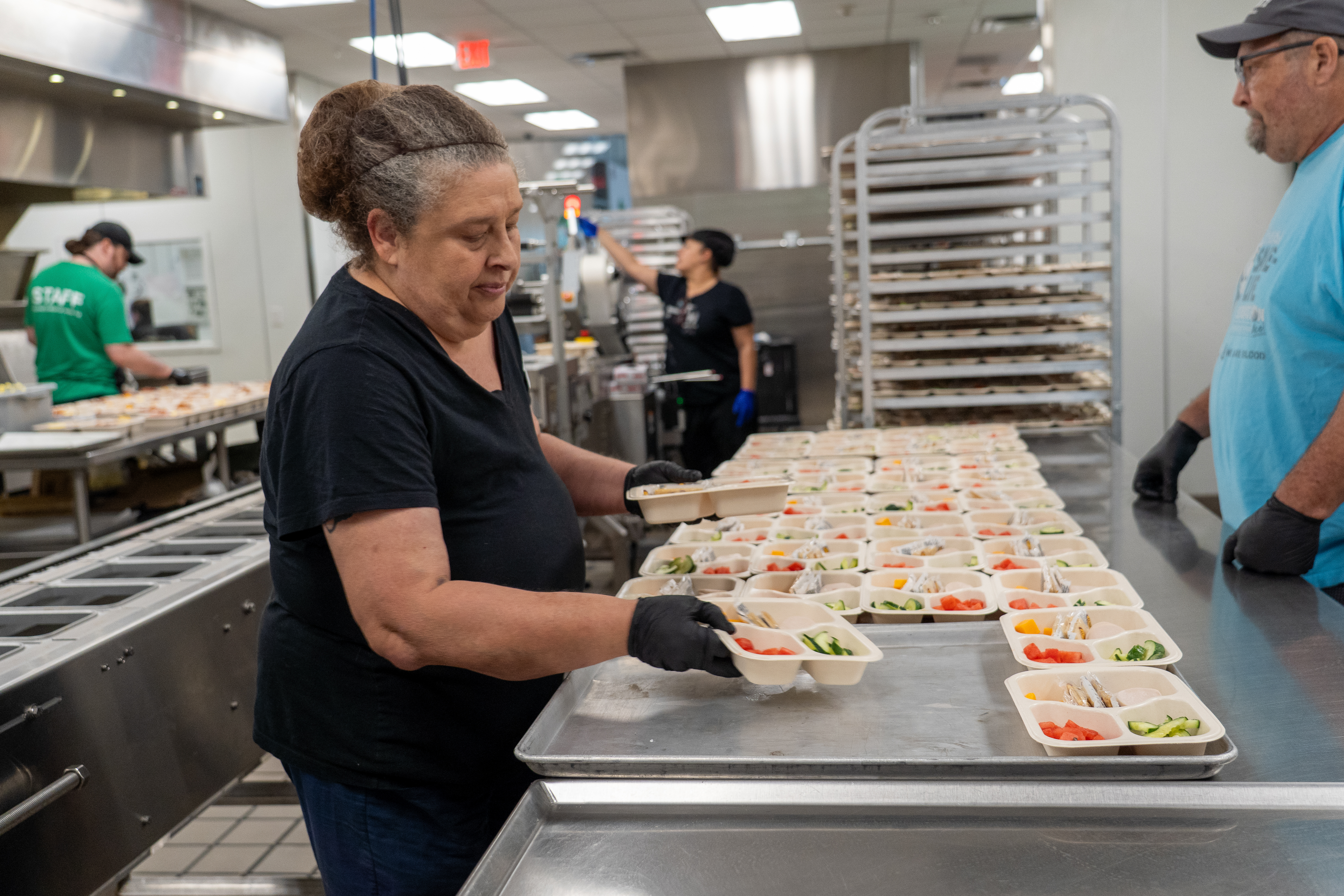 Retired educators prepare free summer meals for kids in the Central Texas Food Bank kitchen.