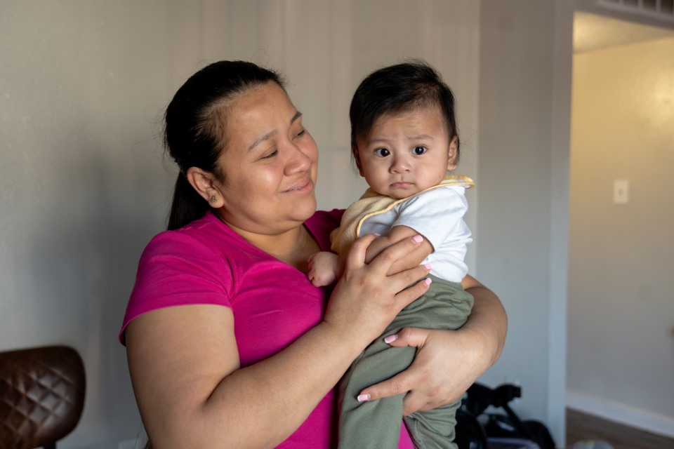 Central Texas Food Bank neighbor mother with baby opening Medically Tailored Meals box