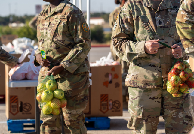 Fort Hood military personnel at CTFB mobile food distribution holding apples