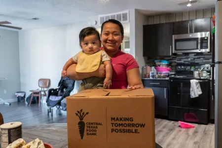 Mom and baby with CTFB's Medically Tailored Meals delivery box